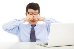 Утомленный молодой бизнесмен тереть его наблюдает с компьтер-книжкой стоковые фото Утомленный молодой бизнесмен тереть его наблюдает с компьтер-книжкой стоковые фото