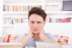 Утомленный студент окруженный книгами стоковое фото rf Утомленный студент окруженный книгами стоковое фото rf