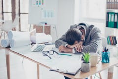 Утомленными бизнесмен перегружанный детенышами спит на таблице в m стоковые фотографии rf Утомленными бизнесмен перегружанный детенышами спит на таблице в m стоковые фотографии rf