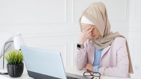 Утомлянные мусульманские работы и типы женщины на ноутбуке, кладут ее стекла и трут ее глаза видеоматериал Утомлянные мусульманские работы и типы женщины на ноутбуке, кладут ее стекла и трут ее глаза видеоматериал