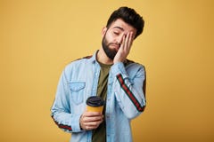 Утомлянный вымотанный студент с сонным выражением, покрывает сторону с ладонью стоковые изображения rf Утомлянный вымотанный студент с сонным выражением, покрывает сторону с ладонью стоковые изображения rf