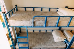Утро внутри спальни общежития с чистыми белыми кроватями для студентов и сиротливых молодых туристов стоковое фото rf Утро внутри спальни общежития с чистыми белыми кроватями для студентов и сиротливых молодых туристов стоковое фото rf