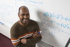 Учитель разрешая уровнения математики на Whiteboard стоковые фото Учитель разрешая уровнения математики на Whiteboard стоковые фото