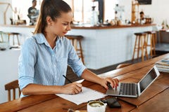 Учить, изучающ Женщина используя портативный компьютер на кафе, работая стоковые фотографии rf Учить, изучающ Женщина используя портативный компьютер на кафе, работая стоковые фотографии rf