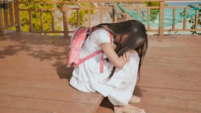 Филиппинская девушка школьницы с рюкзаком сидящ и плачущ около настроения тропического побережья унылого стоковые фото Филиппинская девушка школьницы с рюкзаком сидящ и плачущ около настроения тропического побережья унылого стоковые фото