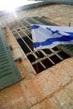 Флаг Израиля на деревянном поляке в окне стоковая фотография rf Флаг Израиля на деревянном поляке в окне стоковая фотография rf