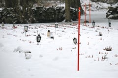 Фонарики со свечами на дворе кладбища серьезном покрытом со снегом в зиме стоковое изображение rf Фонарики со свечами на дворе кладбища серьезном покрытом со снегом в зиме стоковое изображение rf