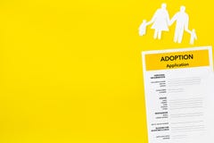 Форма для заявления для принимает ребенка на желтой насмешке взгляда сверху предпосылки вверх стоковая фотография rf Форма для заявления для принимает ребенка на желтой насмешке взгляда сверху предпосылки вверх стоковая фотография rf