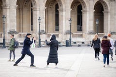 Франция paris 29-ое марта 2018 Молодой человек принимая фото его девушки около Лувр стоковые изображения rf Франция paris 29-ое марта 2018 Молодой человек принимая фото его девушки около Лувр стоковые изображения rf