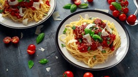 Фрикадельки макаронных изделий спагетти с томатным соусом, базиликом, сыр пармесаном трав на темной предпосылке Стоковое Изображение Фрикадельки макаронных изделий спагетти с томатным соусом, базиликом, сыр пармесаном трав на темной предпосылке Стоковое Изображение