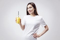 Футболка молодой красивой женщины нося белая серая усмехаясь с апельсиновым соком в руке Портрет изолированный на белой предпосыл стоковое фото Футболка молодой красивой женщины нося белая серая усмехаясь с апельсиновым соком в руке Портрет изолированный на белой предпосыл стоковое фото