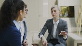 Фьючерсный контракт коммерсантки говоря и duscussing при деловые партнеры сидя на кресле в современном центре офиса Фьючерсный контракт коммерсантки говоря и duscussing при деловые партнеры сидя на кресле в современном центре офиса