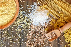 Хлопья мозоль, рис, гречиха, квиноа, пшено и макаронные изделия и мука клейковины свободные на коричневой деревянной предпосылке стоковые фотографии rf Хлопья мозоль, рис, гречиха, квиноа, пшено и макаронные изделия и мука клейковины свободные на коричневой деревянной предпосылке стоковые фотографии rf