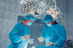 Хирурги объединяются в команду работа с контролем пациента в хирургическом ope стоковое изображение rf Хирурги объединяются в команду работа с контролем пациента в хирургическом ope стоковое изображение rf