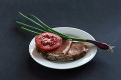 Хлеб ветчины с томатом и лук-пореем на плите, серой предпосылке стоковые фото Хлеб ветчины с томатом и лук-пореем на плите, серой предпосылке стоковые фото