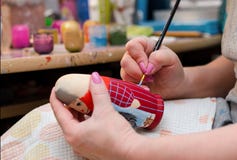 Художник рисует куклу-matryoshka Крупный план руки стоковое изображение rf Художник рисует куклу-matryoshka Крупный план руки стоковое изображение rf