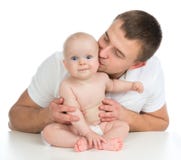 Целовать и huggin ребёнка отца и ребенка счастливой семьи молодой стоковая фотография Целовать и huggin ребёнка отца и ребенка счастливой семьи молодой стоковая фотография