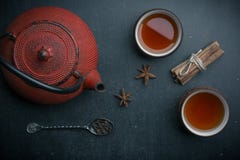 Чайник с ложкой звезды анисовки чая на черной таблице стоковое изображение rf Чайник с ложкой звезды анисовки чая на черной таблице стоковое изображение rf