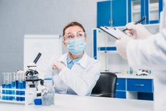частично взгляд ученых в медицинских масках и изумлённых взглядов работая на научном исследовании стоковые изображения частично взгляд ученых в медицинских масках и изумлённых взглядов работая на научном исследовании стоковые изображения