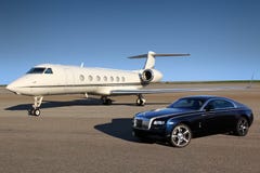 Частный самолет Gulfstream G550 исполнительный при автомобиль призрака Rolls Royce роскошный показанный совместно на международно стоковые изображения rf Частный самолет Gulfstream G550 исполнительный при автомобиль призрака Rolls Royce роскошный показанный совместно на международно стоковые изображения rf