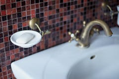 Часть комнаты ванны - таза мытья с бронзовым краном, белым шкафом для мыла, коричневой предпосылки плитки мозаики Запачканное изо стоковые фото Часть комнаты ванны - таза мытья с бронзовым краном, белым шкафом для мыла, коричневой предпосылки плитки мозаики Запачканное изо стоковые фото