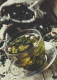 Чашка зеленого чая с лепестками цветка и плодоовощами, винтажным деревянным b стоковые изображения rf Чашка зеленого чая с лепестками цветка и плодоовощами, винтажным деревянным b стоковые изображения rf