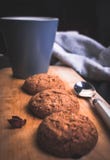 Чашка чаю с домодельными печеньями и ложкой овсяной каши на деревянном стоковая фотография Чашка чаю с домодельными печеньями и ложкой овсяной каши на деревянном стоковая фотография