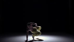 Человек Breakdance в крышке и желтых брюках танцуя breakdance на черноте, тень, замедленное движение сток-видео Человек Breakdance в крышке и желтых брюках танцуя breakdance на черноте, тень, замедленное движение сток-видео