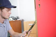 Человек исправляя сломанная дверь стоковое фото rf Человек исправляя сломанная дверь стоковое фото rf