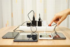 Человек поворачивает переходники силы для мобильных телефонов и таблетки стоковые фотографии rf Человек поворачивает переходники силы для мобильных телефонов и таблетки стоковые фотографии rf