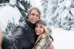 Человек принимая фото Selfie молодой романтичный лес снега улыбки пар внешний Стоковая Фотография Человек принимая фото Selfie молодой романтичный лес снега улыбки пар внешний Стоковая Фотография
