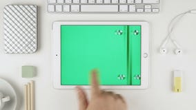 Человек сползая зеленые изображения ключа chroma на авиационном параде iPad Яблока на его стол акции видеоматериалы Человек сползая зеленые изображения ключа chroma на авиационном параде iPad Яблока на его стол акции видеоматериалы