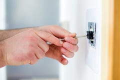 Человек устанавливая выключатель с отверткой стоковые фотографии rf Человек устанавливая выключатель с отверткой стоковые фотографии rf