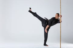 Человек Ninja, разрабатывает метод пинать с ручкой бамбука сражения стоковое изображение Человек Ninja, разрабатывает метод пинать с ручкой бамбука сражения стоковое изображение