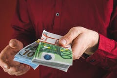 человек в красной рубашке держа пачки денег на красной предпосылке стоковое фото человек в красной рубашке держа пачки денег на красной предпосылке стоковое фото