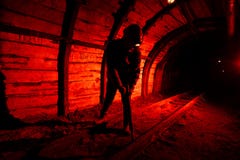 Человек в прозодеждах работы и шлеме с jackhammer на его плече стоит на рельсах Силуэт в красном цвете Горнорабочий стоковые фото Человек в прозодеждах работы и шлеме с jackhammer на его плече стоит на рельсах Силуэт в красном цвете Горнорабочий стоковые фото