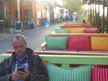 Человек во дне осени умного телефона пользы кафа патио теплом стоковое изображение Человек во дне осени умного телефона пользы кафа патио теплом стоковое изображение