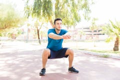 Человек выполняя сидения на корточках перед Jogging на тропе в парке стоковые фото Человек выполняя сидения на корточках перед Jogging на тропе в парке стоковые фото