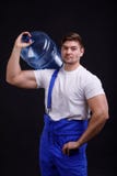 Человек держит более холодную бутылку на его плече против черной предпосылки стоковые изображения Человек держит более холодную бутылку на его плече против черной предпосылки стоковые изображения