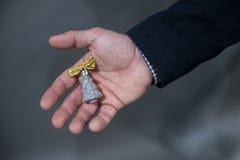Человек держит игрушку рождества в ладони серебряной рождественской елки со смычком стоковые изображения Человек держит игрушку рождества в ладони серебряной рождественской елки со смычком стоковые изображения