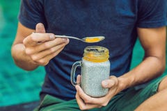Человек ест десерт с семенами и манго chia бассейном в утре здоровая еда, вегетарианская еда, диета и люди стоковое фото rf Человек ест десерт с семенами и манго chia бассейном в утре здоровая еда, вегетарианская еда, диета и люди стоковое фото rf