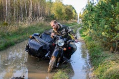 Человек ехать мотоцикл при полученный sidecar вставил на дороге в лесе стоковое фото rf Человек ехать мотоцикл при полученный sidecar вставил на дороге в лесе стоковое фото rf