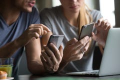 Человек и женщина используя smartphones обсуждая передвижные apps, конец вверх стоковые фото Человек и женщина используя smartphones обсуждая передвижные apps, конец вверх стоковые фото