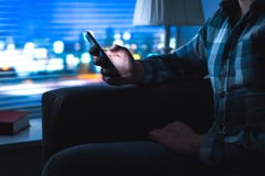 Человек используя дом мобильного телефона поздно на ноче стоковая фотография Человек используя дом мобильного телефона поздно на ноче стоковая фотография