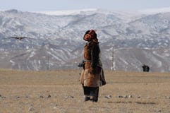 Человек казаха монгольский одел с традиционным обмундированием тренируя беркута для того чтобы уловить лису молит стоковое фото Человек казаха монгольский одел с традиционным обмундированием тренируя беркута для того чтобы уловить лису молит стоковое фото
