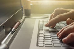 Человек печатает на клавиатуре его ноутбука в офисе стоковые изображения Человек печатает на клавиатуре его ноутбука в офисе стоковые изображения
