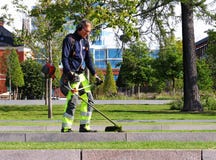 Человек работая на резать траву в городе Umea стоковые фото Человек работая на резать траву в городе Umea стоковые фото