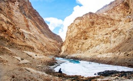 Человек сидя на стороне реки Замороженное река Zanskar и красивая гора Кривая текучести реки Стоковая Фотография Человек сидя на стороне реки Замороженное река Zanskar и красивая гора Кривая текучести реки Стоковая Фотография