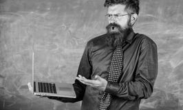 Человек учителя бородатый смутил работу с современной предпосылкой доски компьтер-книжки Выражение хипстера смущенное учителем де стоковая фотография rf Человек учителя бородатый смутил работу с современной предпосылкой доски компьтер-книжки Выражение хипстера смущенное учителем де стоковая фотография rf