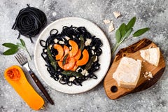 Черные макаронные изделия с зажаренным в духовке сквошом butternut, сыр пармесаном и зажаренным шалфеем Концепция хеллоуина черна стоковая фотография Черные макаронные изделия с зажаренным в духовке сквошом butternut, сыр пармесаном и зажаренным шалфеем Концепция хеллоуина черна стоковая фотография